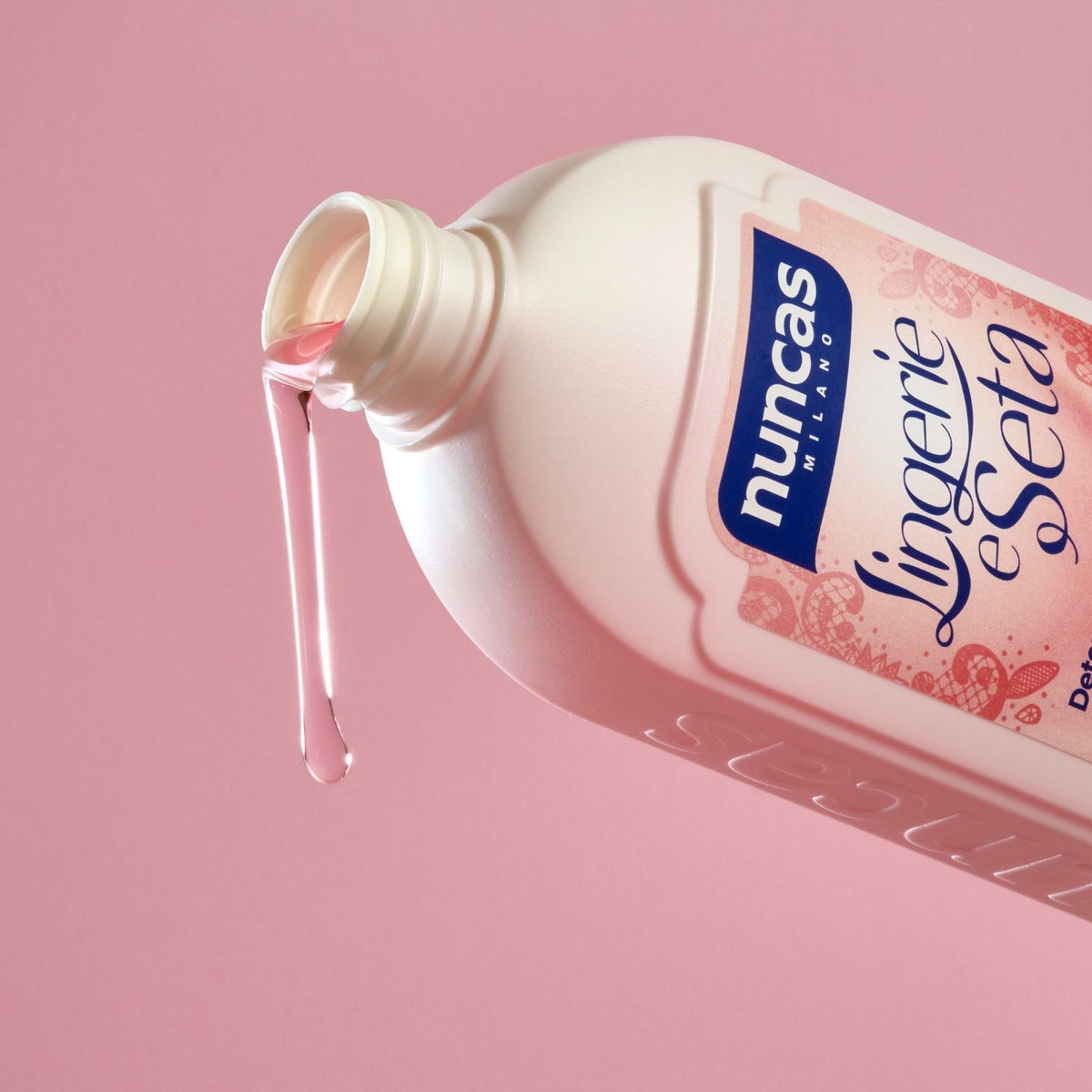 Lingerie e seta Nuncas fotografato mentre versa su sfondo neutro